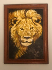 Tanzanian painting of a lion looking straight ahead. Symbolic of Compassion..